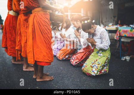 Femme thaïlandaise rendent hommage à un moine bouddhiste au matin. Banque D'Images