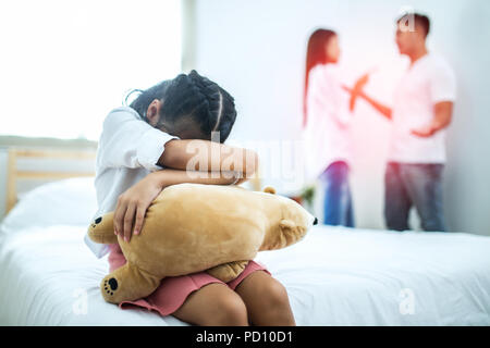 La malheureuse fille assise près de la soutenant les parents sur le lit Banque D'Images