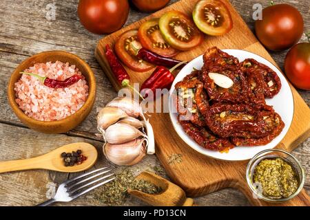 Les tomates séchées marinées dans l'huile d'olive avec l'ail. Graines de tournesol avec des tomates sur une vieille table en bois Banque D'Images