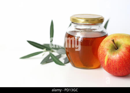 Rosh Hashana, Nouvel An juif Cuisine traditionnelle Vie encore la composition. Arrangement alimentaire au miel pot, pomme fruit et branche d'olivier sur fond de table blanc. Banque D'Images