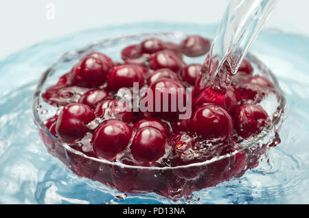 Laver les cerises dans un bol avec de l'eau Banque D'Images