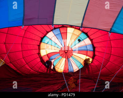 L'ombre de deux personnes du contrôle d'un ballon à air chaud coloré comme il est gonflé. Banque D'Images