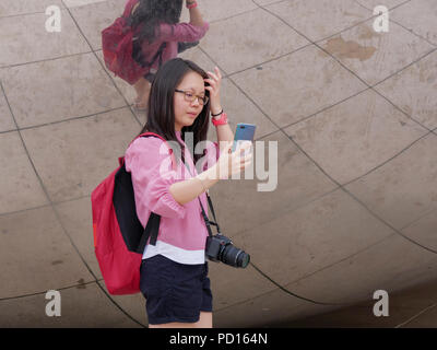 Une jeune femme prend un à selfies Cloud Gate à Chicago's Millennium Park. Banque D'Images