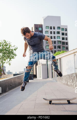 Faire un tour de skate skateur ollie dans la rue d'une ville Banque D'Images