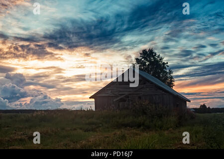 Une ancienne grange se trouve sur le champs d'été dans une soirée à la fin de l'été du nord de la Finlande. Les nuits sont de plus en plus sombre que l'automne est presque Banque D'Images