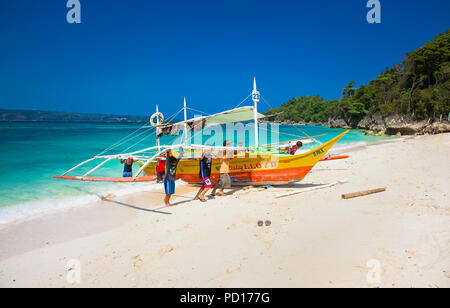 BORACAY, PHILIPPINES-MARS 21, 2016 : les pêcheurs locaux prennent le bateau traditionnel de la rive à plage de Puka le 21 mars 2016. L'île de Boracay. Philippin Banque D'Images