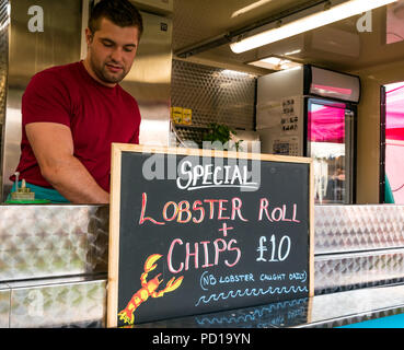 North Berwick, Royaume-Uni. 4 août 2018. North Berwick, Écosse, Royaume-Uni : un homme servant dans un restaurant de fruits de mer extérieur à emporter vendant des petits pains au homard et des frites Banque D'Images