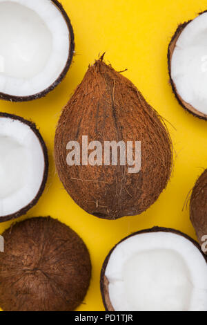 Été tropical coconut fond. la moitié et l'ensemble des noix de coco sur un fond jaune Banque D'Images