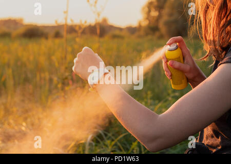 L'utilisation de spray anti moustiques dehors à la randonnée. Close-up of young female backpacker'appliquer un insectifuge sur les mains Banque D'Images