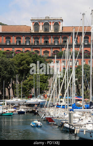 Charmant petit port de plaisance avec de nombreux bateaux de plaisance et le Palazzo Reale di Napoli à l'arrière-plan - Naples, Italie Banque D'Images