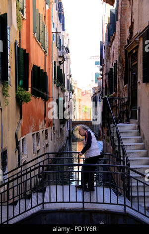 Hauts avec bâton de marche franchit lentement une passerelle à Venise, Italie Banque D'Images