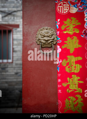 Chinois traditionnel avec entrée de porte poignée bronze dragon rouge et panneau de bienvenue Banque D'Images