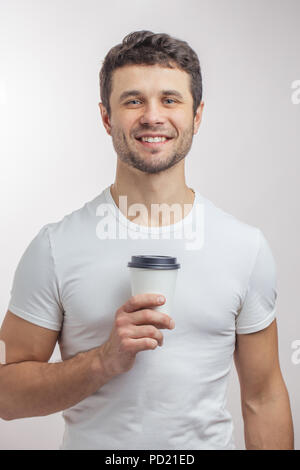 Close up portrait. Heureux bel homme avec tasse de papier de café du matin. Bon matin avec un plateau/bouilloire. à emporter. temps de pause café Banque D'Images