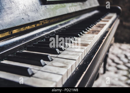 Vieux piano cassé abandonné sur la rue sous le ciel ouvert Banque D'Images