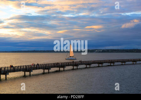 La voile sur Bellingham Bay par boardwalk au Boulevard Park de Bellingham dans l'État de Washington pendant le coucher du soleil Banque D'Images