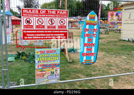 Règles de la juste et une affiche publicitaire à la Warrington Bank Park qui avait été clôturée d'une aire de jeu avec une fête foraine et une plage Banque D'Images