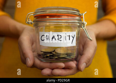 Femme collecter de l'argent pour la charité et est titulaire d'pot avec des pièces. Banque D'Images