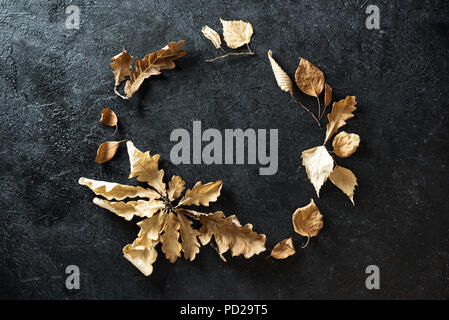 Composition d'automne. Couronne d'automne sec avec des feuilles jaunes sur fond noir. Mise à plat, vue du dessus, copiez l'espace. Banque D'Images