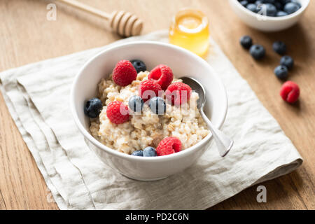 Bouillie d'avoine avec les baies fraîches dans un bol, selective focus Banque D'Images