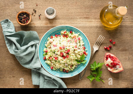Taboulé salade de couscous végétarien arabe avec graines de grenade, le persil et l'huile d'olive. Vue d'en haut Banque D'Images