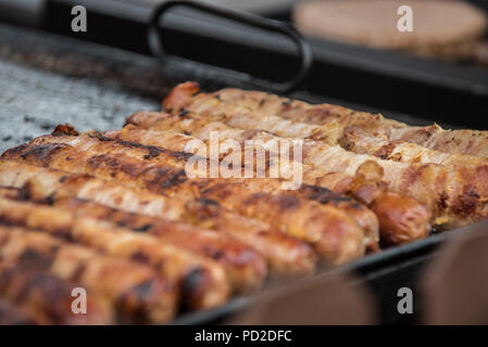 Enveloppé de bacon hot-dogs cuits sur le grill extérieur au pays juste pour les clients affamés. Banque D'Images