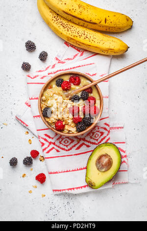 Petit déjeuner sain. Bol à smoothie aux fruits rouges. L'avocat de la crème glacée banane vegan aux fruits rouges et muesli dans un bol en bois, vue du dessus. Banque D'Images