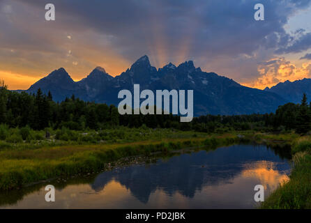 Dans cette vue, les rayons de lumière du soleil qui se tourner vers le haut sur les sommets de la chaîne de montagnes Teton à Grand Teton National Park, Wyoming, USA Banque D'Images