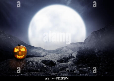 Spooky jack-o-lanterne sur rocky mountain avec lune background Banque D'Images