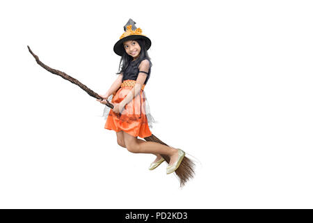 Jolie fille asiatique sorcière volant sur un balai magique isolé sur fond blanc Banque D'Images