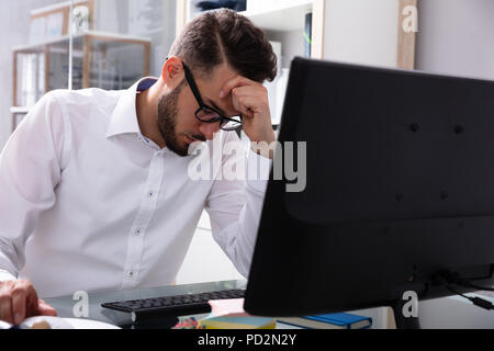 Souligné Young Businessman Sitting Near Computer in Office Banque D'Images
