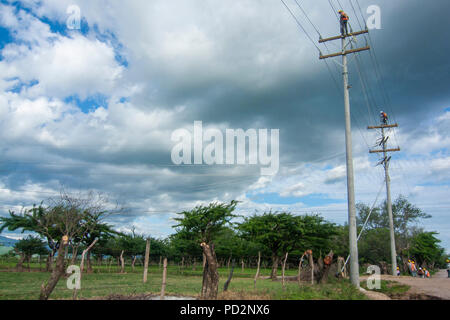 Les travailleurs qui travaillent dans les tours pour la connexion de nouvelle ligne de distribution de l'électricité à la région rurale du Honduras Banque D'Images