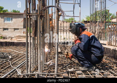 Travailleur de la construction d'armature de métal de soudure pour le déversement de fondation. francs, des personnes réelles Banque D'Images