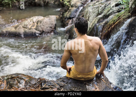 Homme assis par flux Banque D'Images