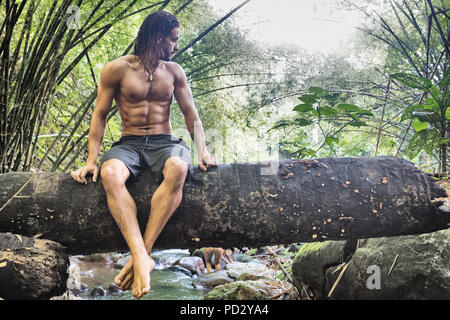 L'homme sur tronc d'arbre au ruisseau dans la forêt tropicale, Ceara, Brésil, Guaiuba Banque D'Images