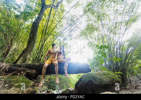 Couple sur tronc d'arbre au ruisseau dans la forêt tropicale, Ceara, Brésil, Guaiuba Banque D'Images