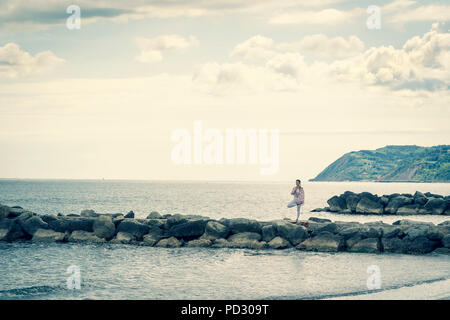 Woman practicing yoga on beach Banque D'Images