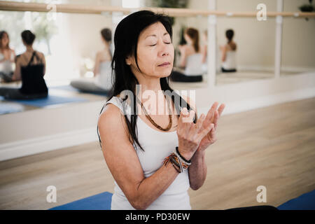 Woman in yoga pose, miroir en arrière-plan Banque D'Images