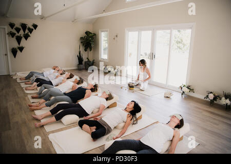 Les femmes dans la classe de yoga relaxation après pose à retreat Banque D'Images