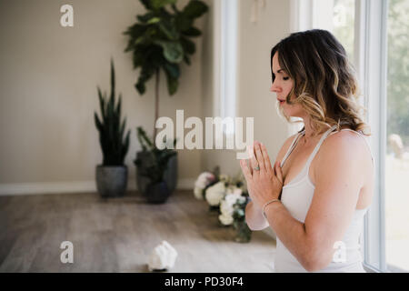 Femme avec des paumes fermées en posture de méditation Banque D'Images