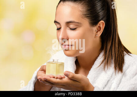 Portrait de femme en robe blanche odeur spa parfum huile essentielle.Girl holding petite bouteille avec fraîcheur. Banque D'Images