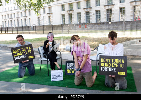 London UK, 6 août 2018. Amnesty International UK stunt. Militant à Theresa peut masquer est montré trois ignorant la torture 'victimes' dans stunt mettant en lumière l'appel des militants pour l'enquête sur la participation britannique à la torture. Immédiatement après le stunt, Amnistie, grâce, à la liberté et à l'abri de la torture a remis une pétition, forte de 27 000 à 10 Downing Street avec un appel officiel de la torture une enquête.C opyright Carol Moir/AlamyLiveNews Banque D'Images