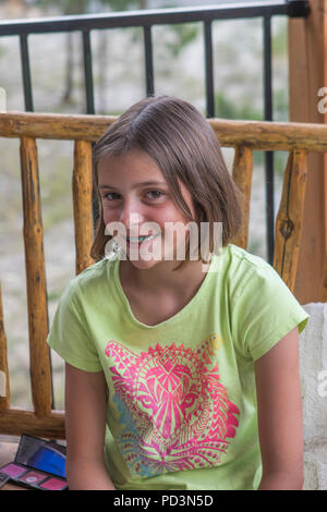 Jolie jeune fille de 8 ans, à l'extérieur od, appareil photo, portant des accolades, un miroir dans le fond du bac Banque D'Images