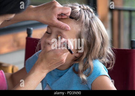 Jeune, jolie femme, en haut bleu, à l'extérieur, ayant de fait sur ses yeux. Banque D'Images