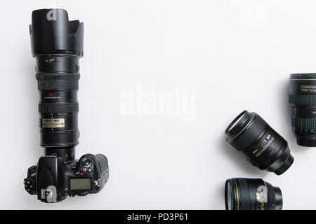 Vue du haut vers le bas de l'équipement de l'appareil photo sur la table blanche, reflex numérique avec zoom téléobjectif et 3 lentilles Banque D'Images