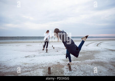 Les femmes en équilibre sur les souches de bois sur la plage, Odessa, Ukraine Banque D'Images