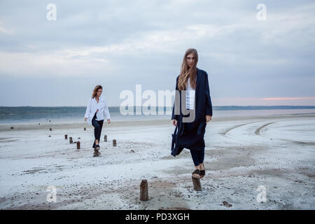 Les femmes en équilibre sur les souches de bois sur la plage, Odessa, Ukraine Banque D'Images