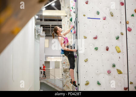 Photo de jeune athlète à l'entraînement sur mur pour l'escalade de rocher Banque D'Images