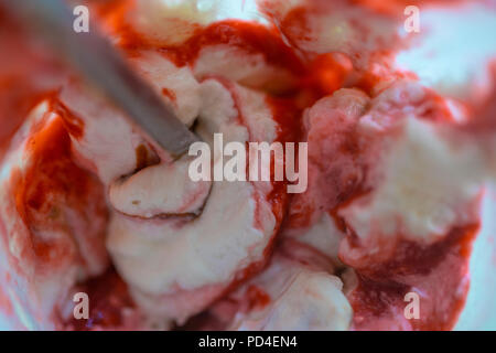 Close up of fresh strawberry ice cream dans récipient en métal et crème glacée fond texturé assis Banque D'Images