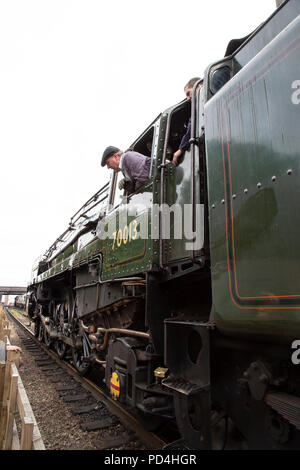 Pilote et moteur à pompier hors de la cabine sur B.R. Locomotive vapeur 70013 'Oliver Cromwell' 7P6F Classe Britannia Banque D'Images