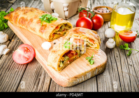 Strudel aux légumes salés faits maison, la cuisson de l'automne, avec des tomates, poivrons, champignons, fond de bois copy space Banque D'Images